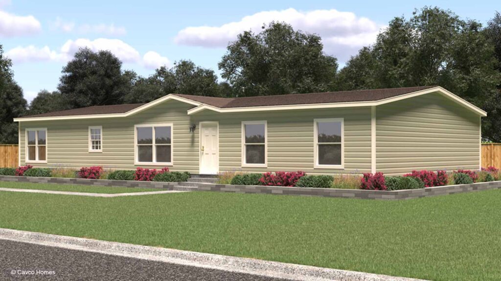 Single-story beige manufactured home with white trim, a landscaped front yard, and a welcoming sidewalk.